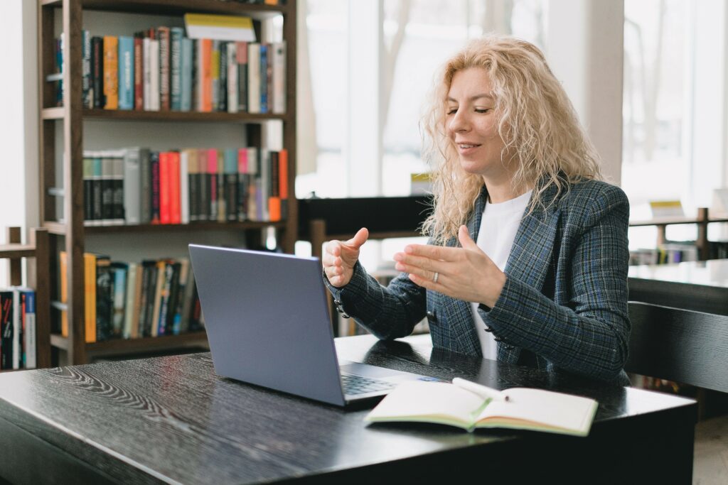 Woman in an office gesturing at a laptop